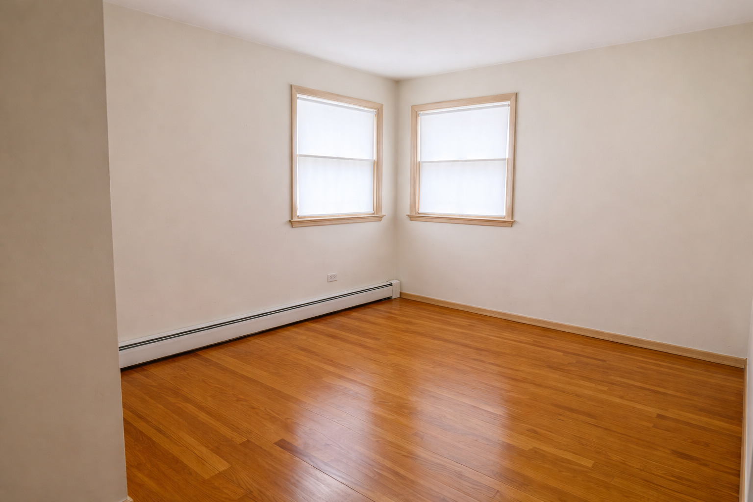 8304 W Forest, Unit 3W Chicago, IL 60634 - Photo 5 of 8 an empty room with wooden floor and windows