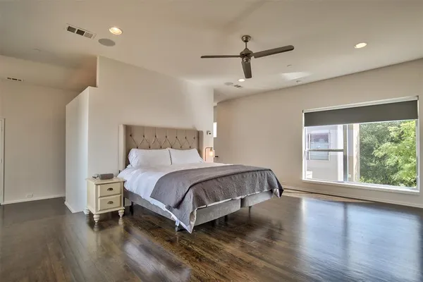 a bedroom with a bed and a large window
