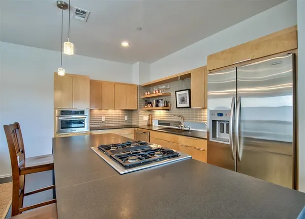 a kitchen with stainless steel appliances granite countertop a stove and a refrigerator