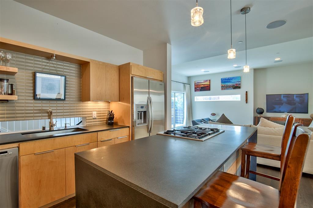 5205 Capitol Avenue, Unit 1 Dallas, TX 75206 - Photo 27 of 39 a kitchen with stainless steel appliances granite countertop a sink dishwasher a stove a refrigerator a dining table and chairs with wooden floor