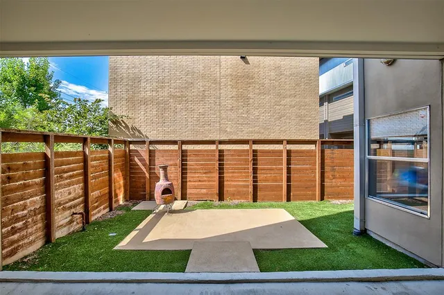 a backyard of a house with garden and outdoor seating