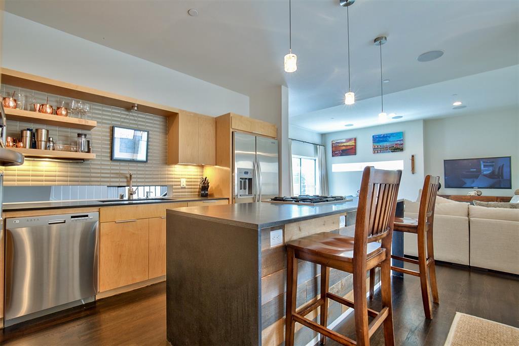 5205 Capitol Avenue, Unit 1 Dallas, TX 75206 - Photo 10 of 39 a kitchen with stainless steel appliances granite countertop a stove a sink a refrigerator a dining table and chairs with wooden floor