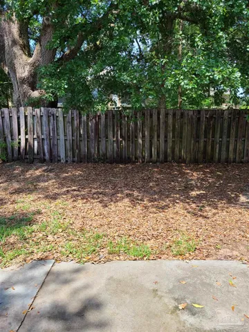 a view of wooden fence and trees in the background