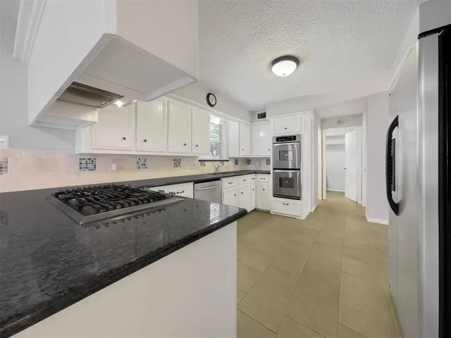 a kitchen with stainless steel appliances granite countertop a refrigerator sink and cabinets