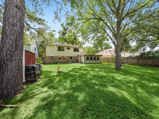 a view of a house with backyard and a tree