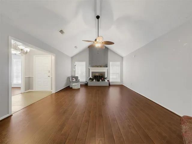 a view of empty room with wooden floor and fireplace