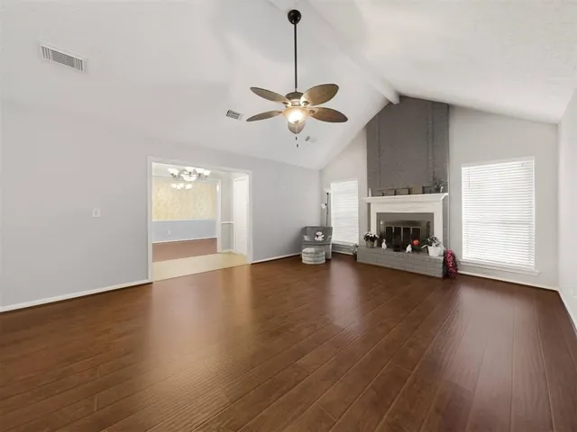 a view of empty room with fireplace and wooden floor