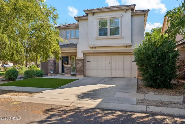 a front view of a house with a yard and a garage