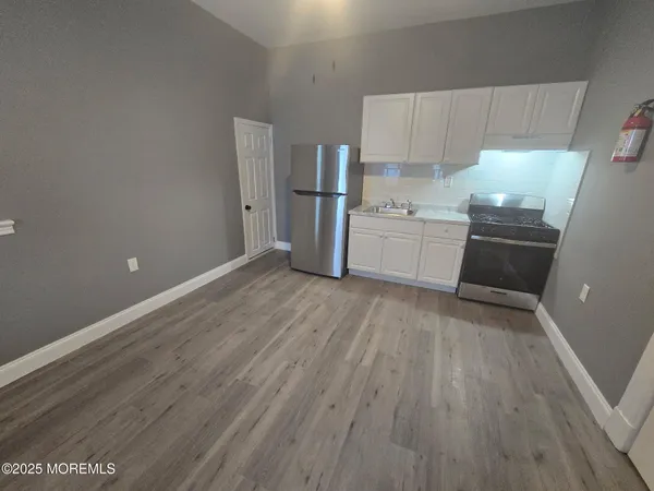 a kitchen with granite countertop a refrigerator and a stove top oven