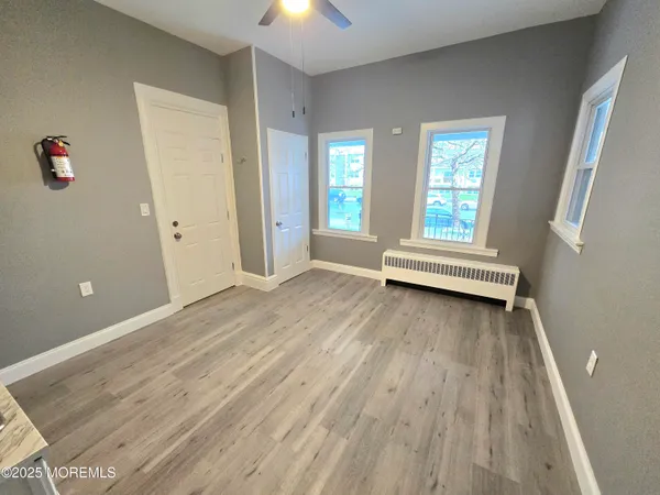 an empty room with wooden floor and windows