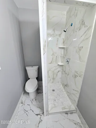 a bathroom with a toilet and a shower