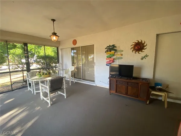 a living room with furniture a flat screen tv and a large window