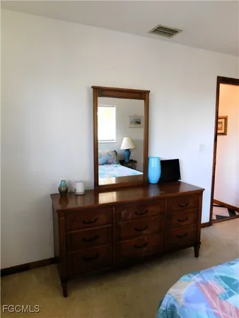 a room with a bed and a dresser