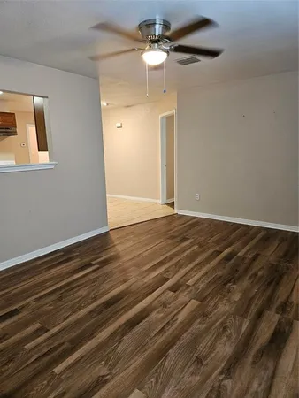 a view of an empty room with a chandelier fan