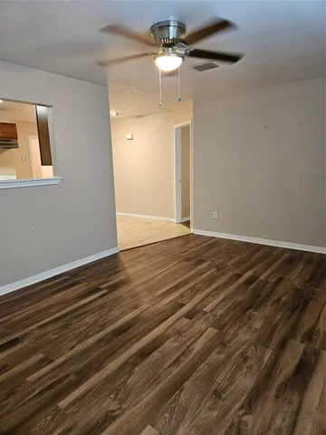 a view of an empty room with a chandelier fan