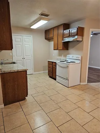 a kitchen with a stove top oven and cabinets
