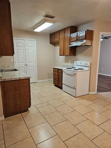 a kitchen with a stove top oven and cabinets