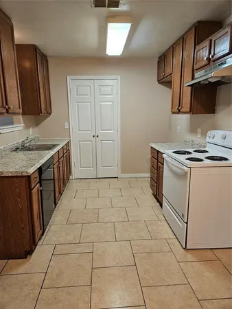 a kitchen with a stove top oven and cabinets