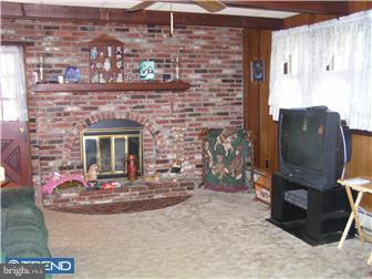 245 Holly Road Clayton, NJ 08094 - Photo 2 of 8 a view of a fireplace with a potted plant in front of it