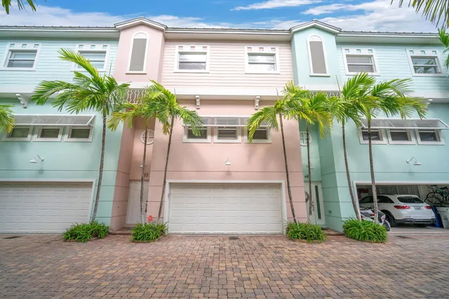 a front view of a house with garage and plants