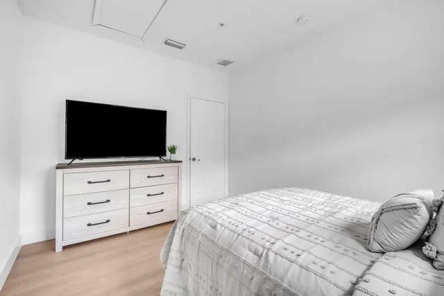 a bedroom with a bed and flat screen tv