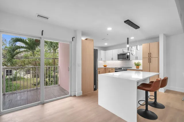 a open kitchen with stainless steel appliances granite countertop a sink and a refrigerator