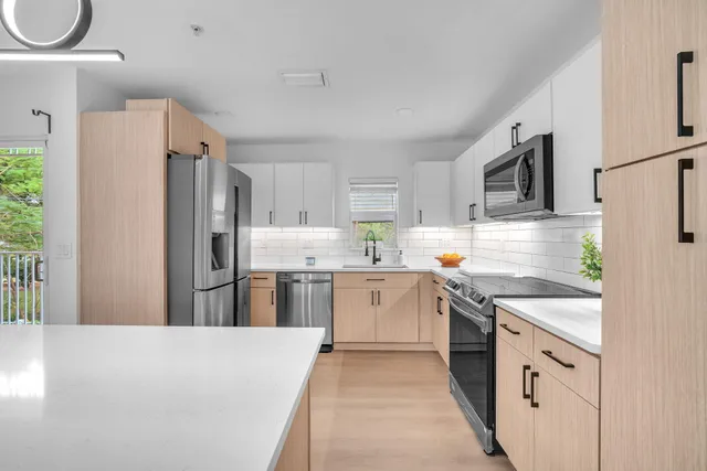a kitchen with refrigerator a sink and white cabinets
