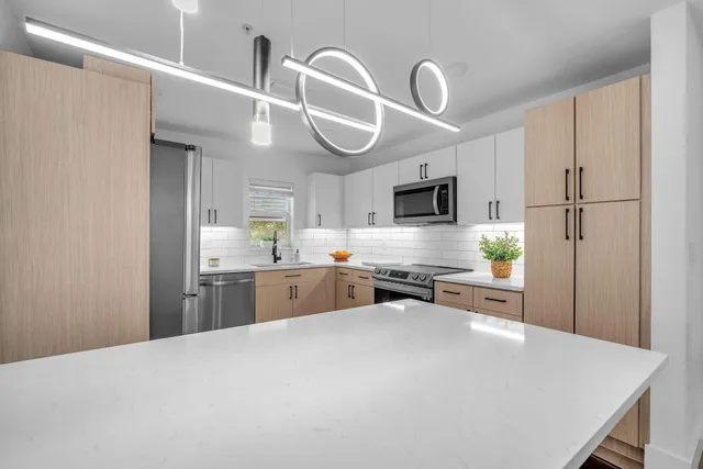 a kitchen with stainless steel appliances granite countertop a sink refrigerator and cabinets