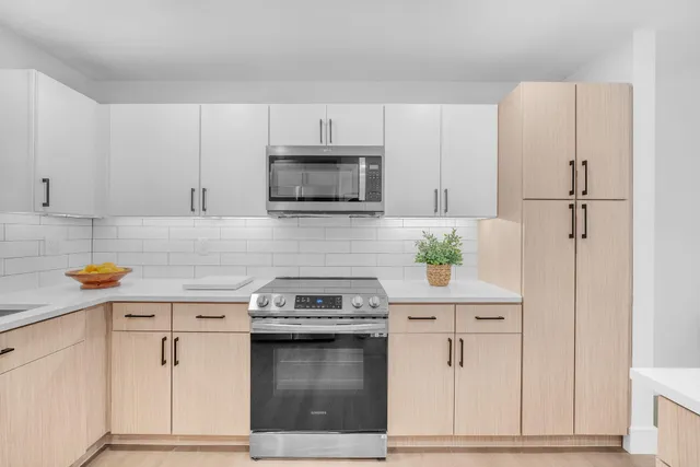 a kitchen with white cabinets and appliances