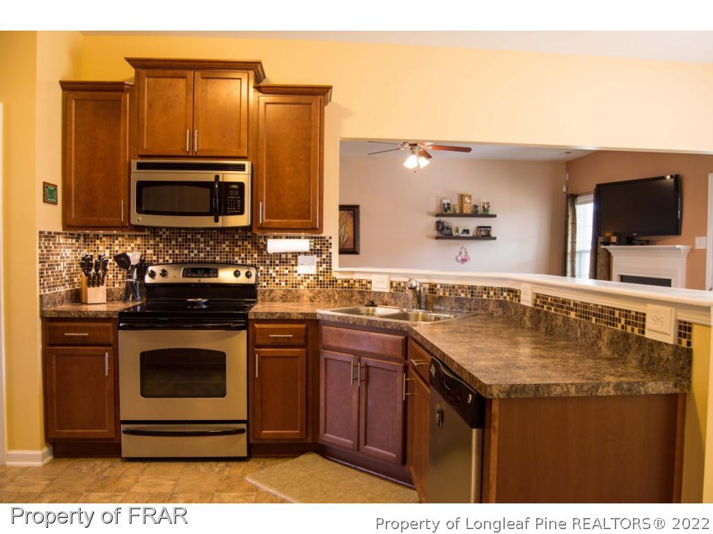 1444 Rough Rider Lane Parkton, NC 28371 - Photo 13 of 36 a kitchen with a sink stove and microwave