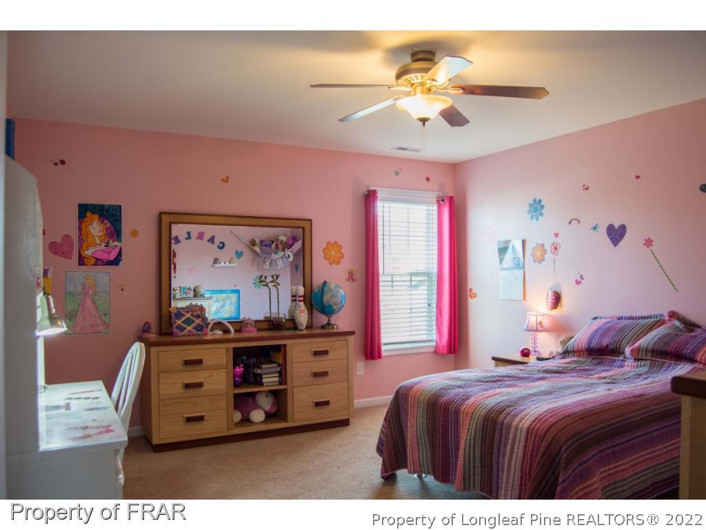 1444 Rough Rider Lane Parkton, NC 28371 - Photo 28 of 36 a bedroom with a bed and a chandelier