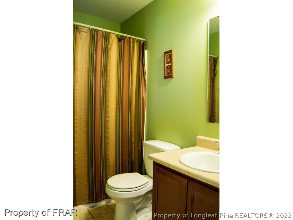 1444 Rough Rider Lane Parkton, NC 28371 - Photo 32 of 36 a bathroom with a sink a toilet and shower curtain
