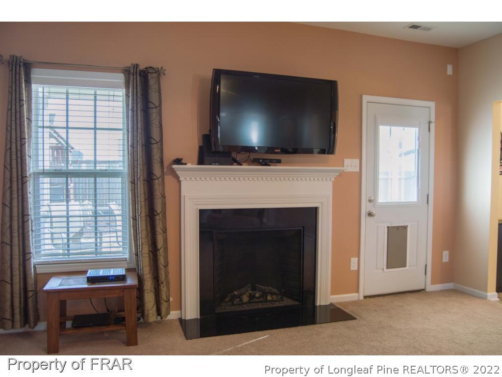 1444 Rough Rider Lane Parkton, NC 28371 - Photo 7 of 36 a living room with a fireplace and a flat screen tv