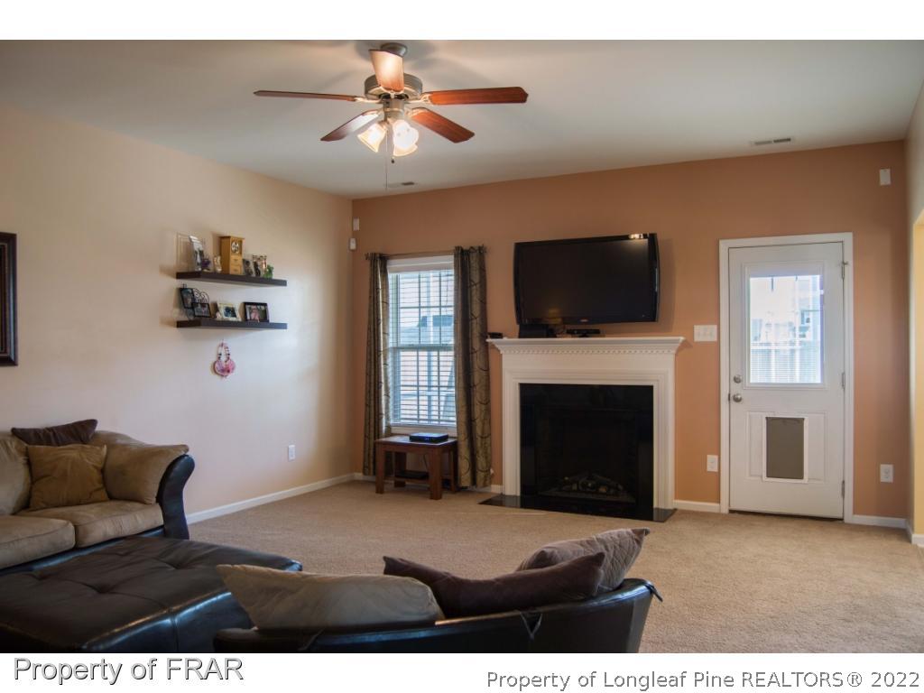 1444 Rough Rider Lane Parkton, NC 28371 - Photo 8 of 36 a living room with furniture a fireplace and a flat screen tv