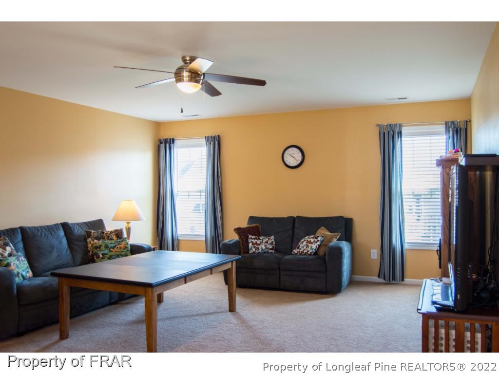 1444 Rough Rider Lane Parkton, NC 28371 - Photo 10 of 36 a living room with furniture a ceiling fan and a flat screen tv