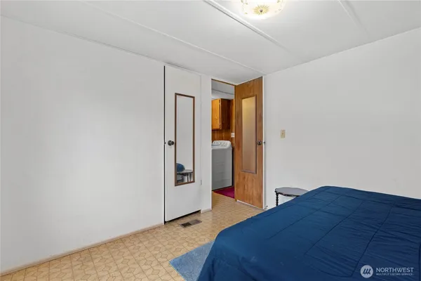 a bedroom with a bed and a refrigerator