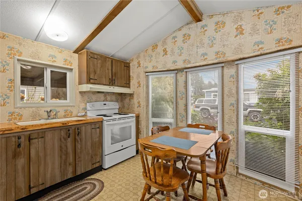 a kitchen with a table chairs sink and cabinets