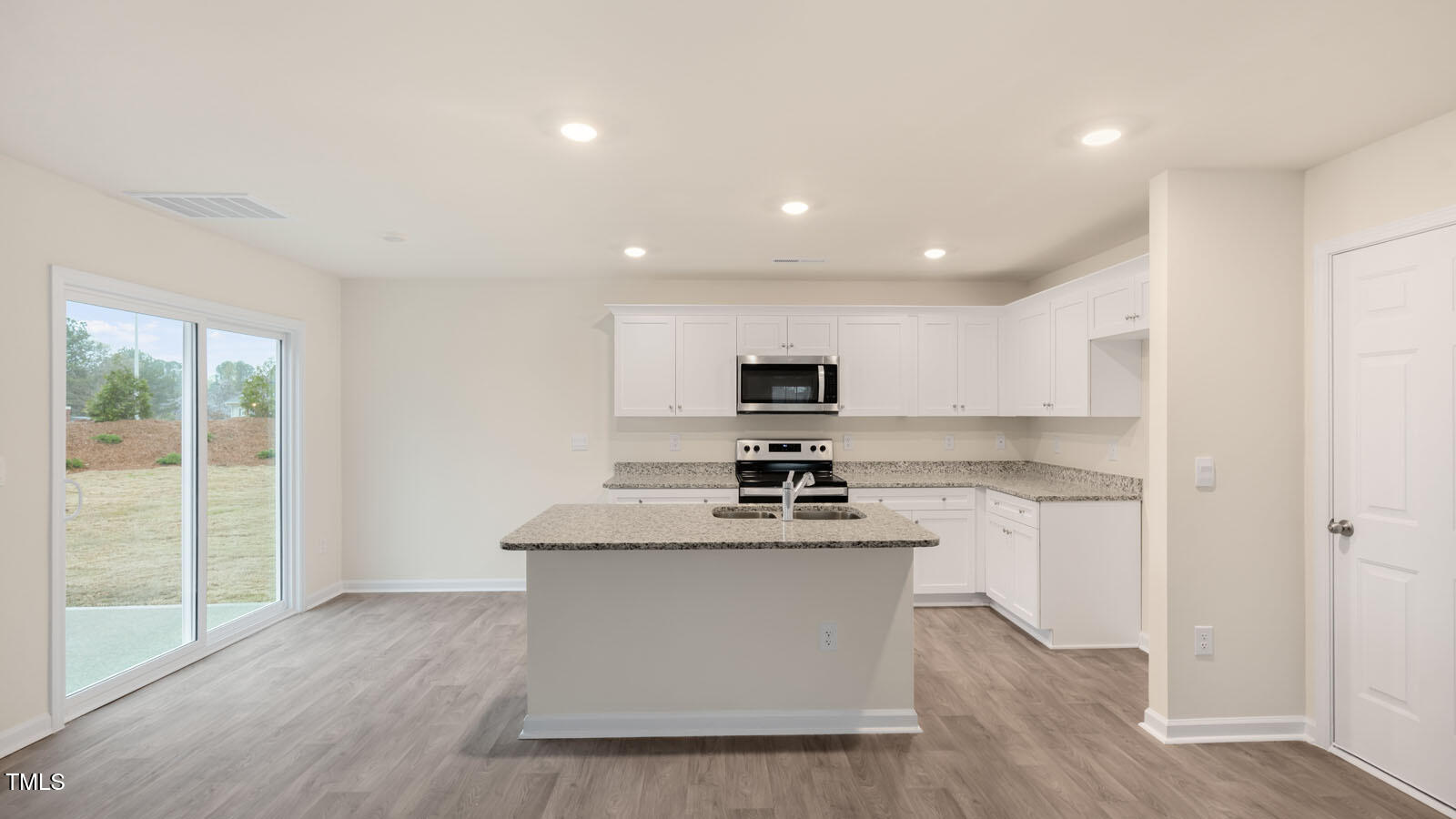 3604 Sorda Court Raleigh, NC 27610 - Photo 4 of 25 a kitchen with stainless steel appliances a stove top oven a sink a refrigerator and white cabinets with wooden floor