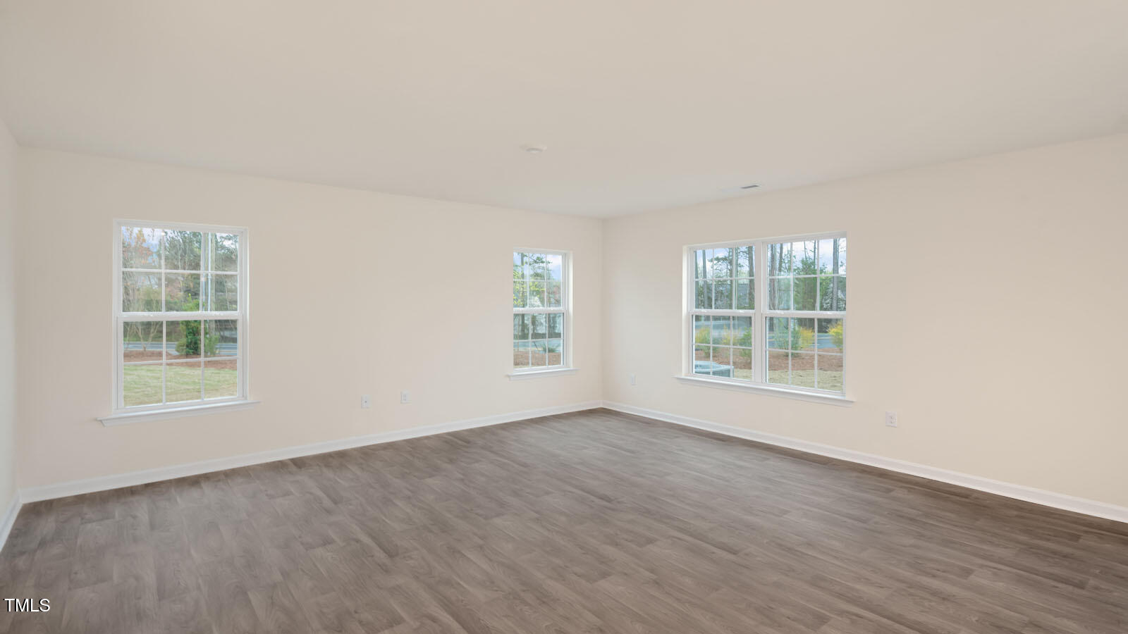3604 Sorda Court Raleigh, NC 27610 - Photo 8 of 25 an empty room with wooden floor and windows