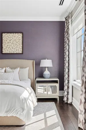 a bed with a white comforter pillows and a chair