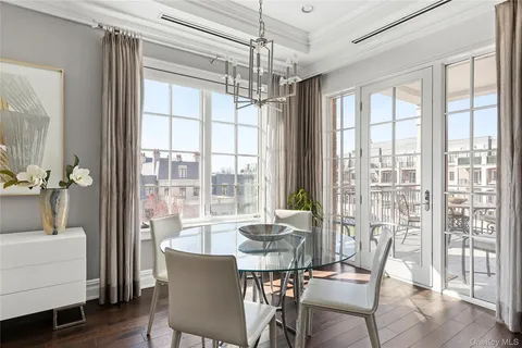 a view of a dining room with furniture large windows and wooden floor