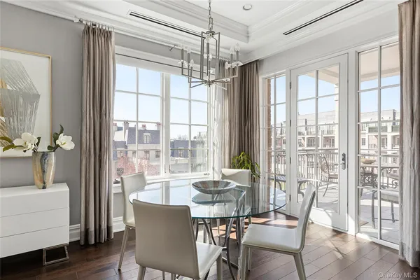 a view of a dining room with furniture large windows and wooden floor