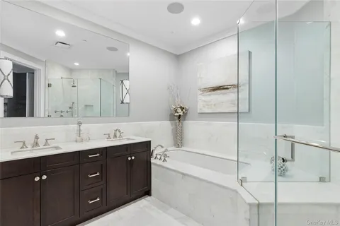 a bathroom with a double vanity sink mirror double and shower