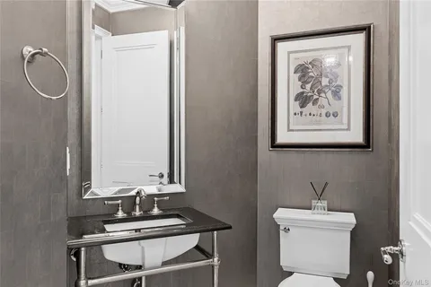 a bathroom with a toilet a sink and mirror