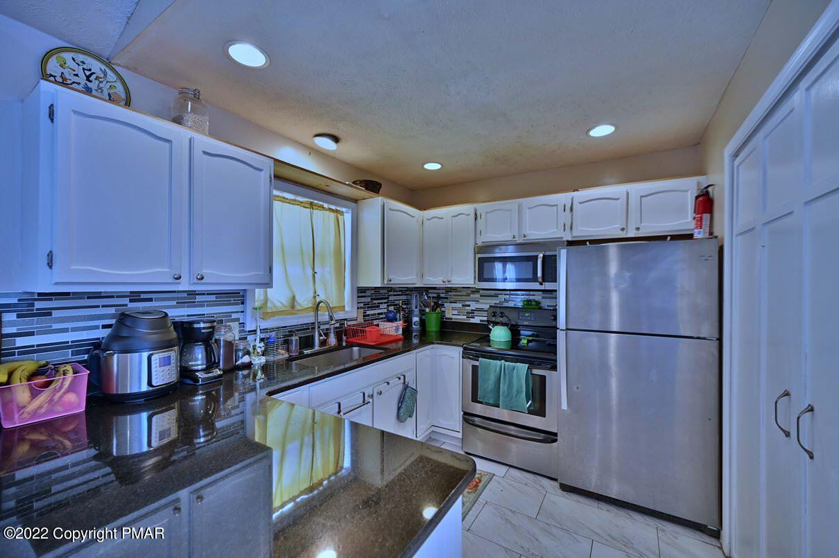 1039 Dancing Ridge Road East Stroudsburg, PA 18302 - Photo 14 of 40 a kitchen with stainless steel appliances granite countertop a refrigerator sink and cabinets