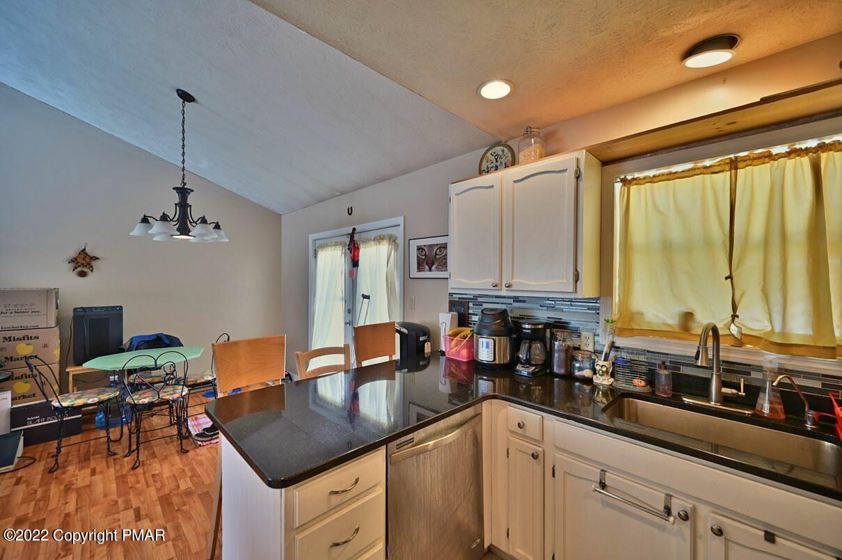 1039 Dancing Ridge Road East Stroudsburg, PA 18302 - Photo 17 of 40 a kitchen with a sink dishwasher a dining table and chairs with wooden floor