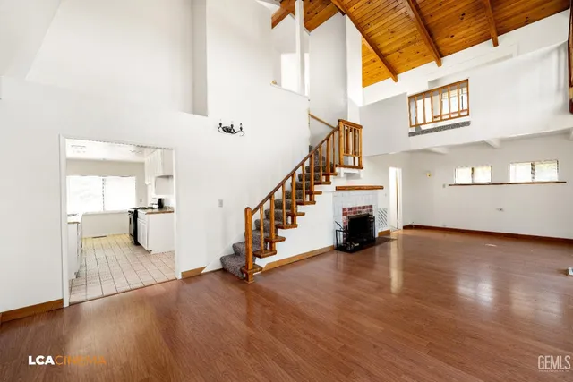 a view of a livingroom with wooden floor and stairs