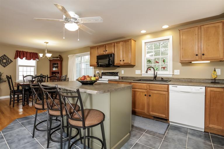 7 Whitecliff Road Buzzards Bay, MA 02532 - Photo 6 of 21 a kitchen with stainless steel appliances granite countertop a stove top oven a sink a dining table and chairs with wooden floor