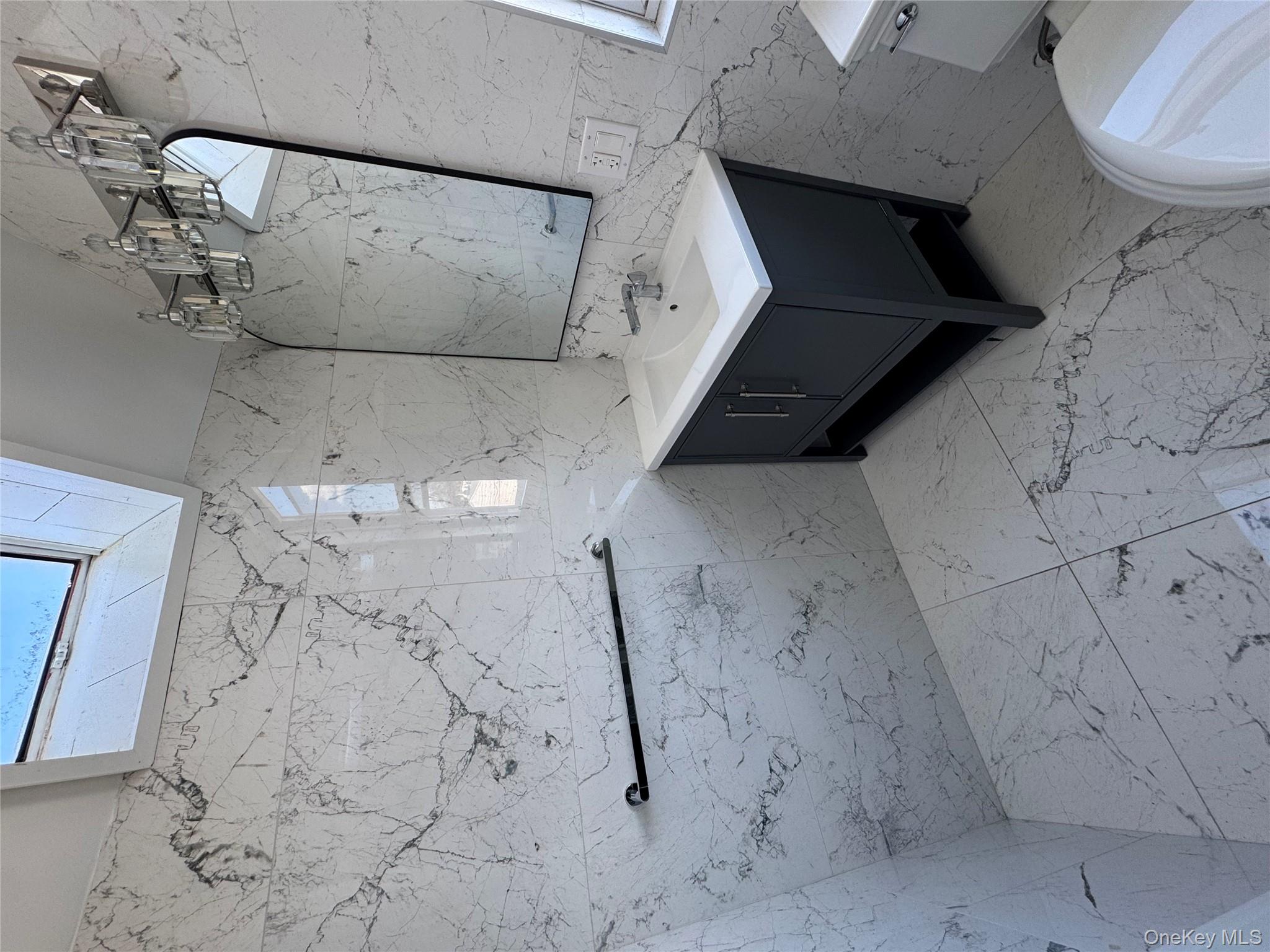 88-36 77th Street Queens, NY 11421 - Photo 16 of 19 a bathroom with a sink a mirror and shower