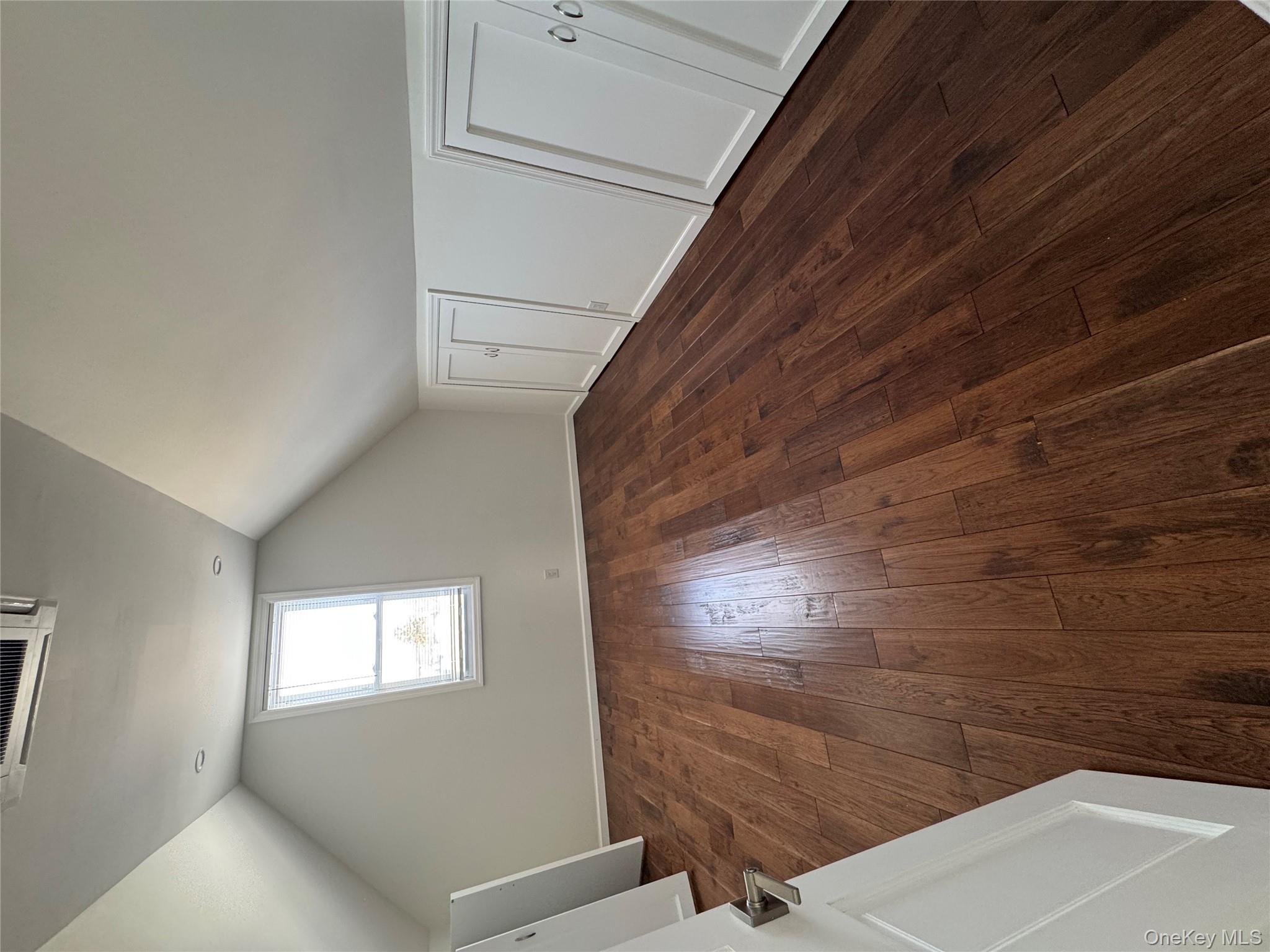 88-36 77th Street Queens, NY 11421 - Photo 18 of 19 an empty room with wooden floor and windows